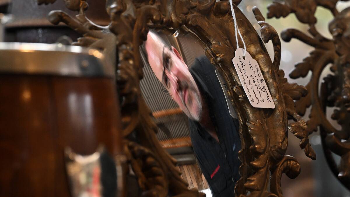 Adam Iuston looks at one of the antique French mirrors that was just delivered to his store. Picture by Gareth Gardner
