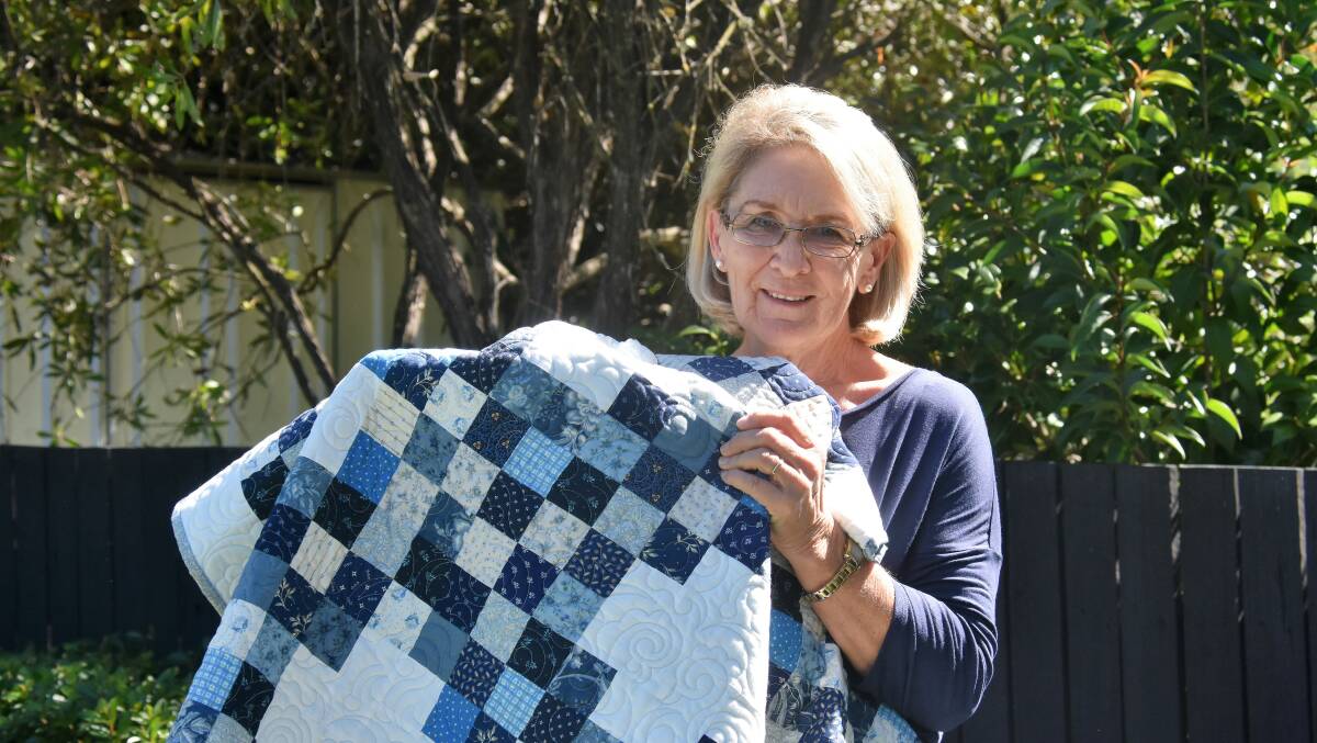 PATCHES:  Quilting and Needlework Exhibition convener Robyn Wood with the queen-sized quilt which will be raffled off over the weekend.