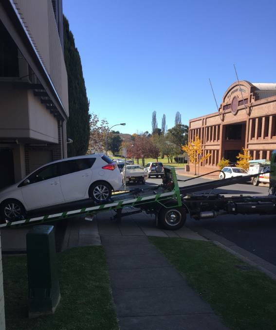 Seized: The stolen white Toyota Corolla is unloaded at Armidale Police Station after it was dumped in Judith St.