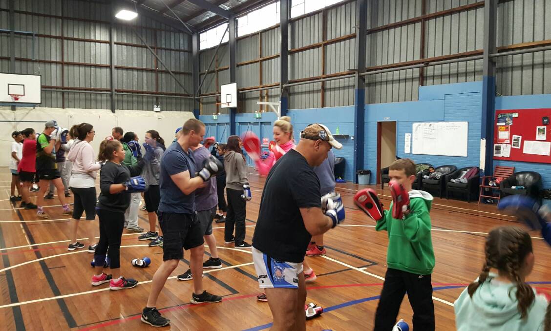 Packing a punch: The boxing sessions can attract more than 80 participants, top, and aims to build self-discipline, respect and recognition for local kids.