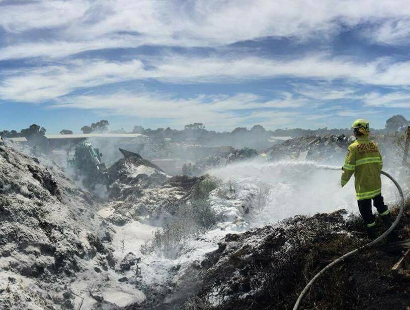 Scene declared safe: A Fire and Rescue NSW firefighter spreads a layer of foam over the blaze that broke out in Armidale. Photo: Fire and Resce NSW Armidale