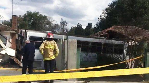 The bus mounted the curb at about midday before hitting the houses. Photo: Nine News