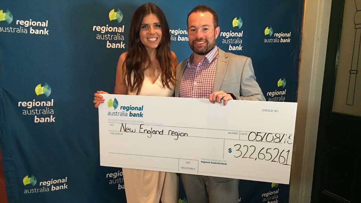COMMUNITY SUPPORT: Marketing co-ordinator Rebecca Stone and regional manager Dane O'Connor with a cheque for more than $320,000 which was handed back to the New England region from the bank's profits. Picture: Laurie Bullock