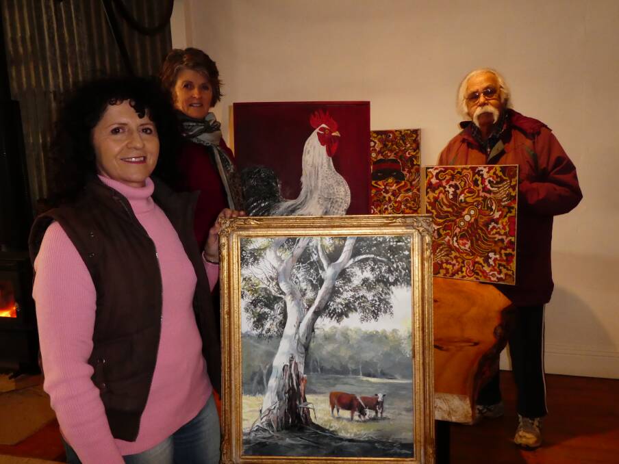 LOCAL ART ON SHOW: Local artists Kay Smith, Fiona Smith and Brian Irving discuss possible entries for the Guyra TroutFest art show. Photo: Contributed.