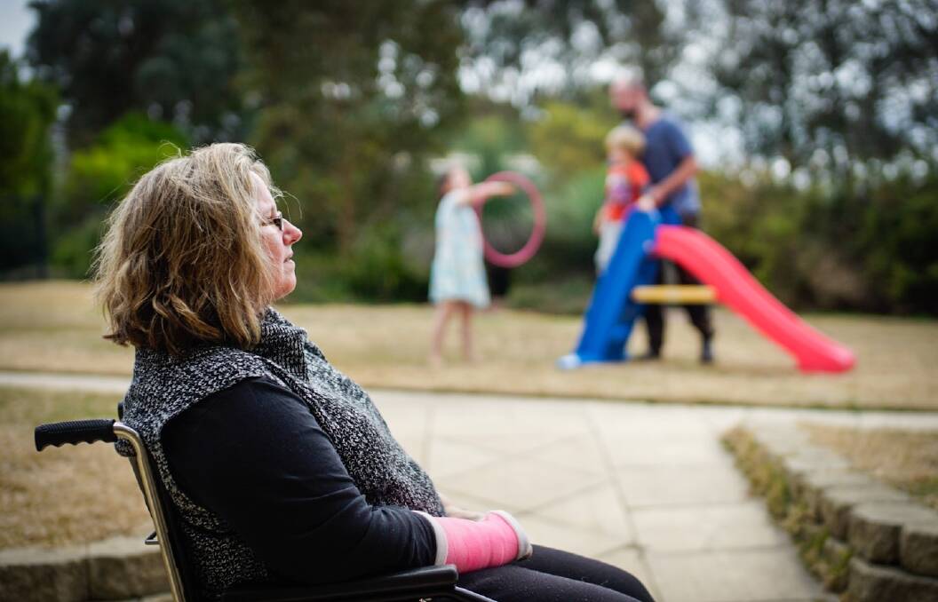 TOGETHER: Clare Vickery looks on as her family play in their new Armidale backyard.