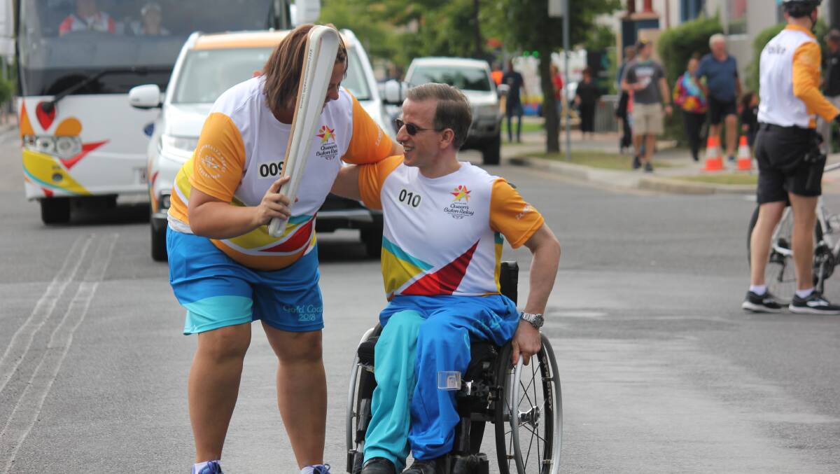 SPECIAL MEMORY: Rochelle Joyce passes the Queen's Baton to Para powerlifter Wayne Sharpe at the event which ran through town on Thursday. 