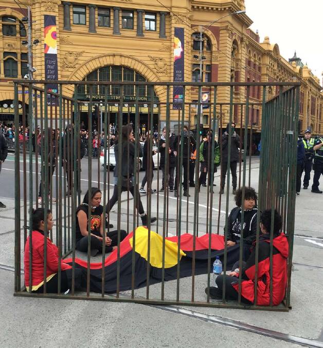 PROTEST: The four women locked inside the cage for the peaceful agitation outside Flinders Street station in Melbourne. Photo: Arika Waulu