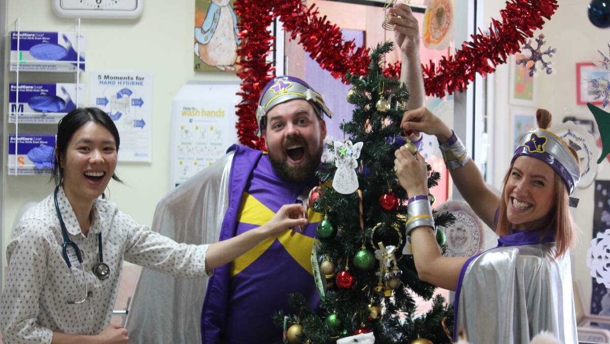 HELPING HAND: Armidale Hospital doctor Natalie Yeung decorates the Children's Ward Christmas tree with Captain Starlight.