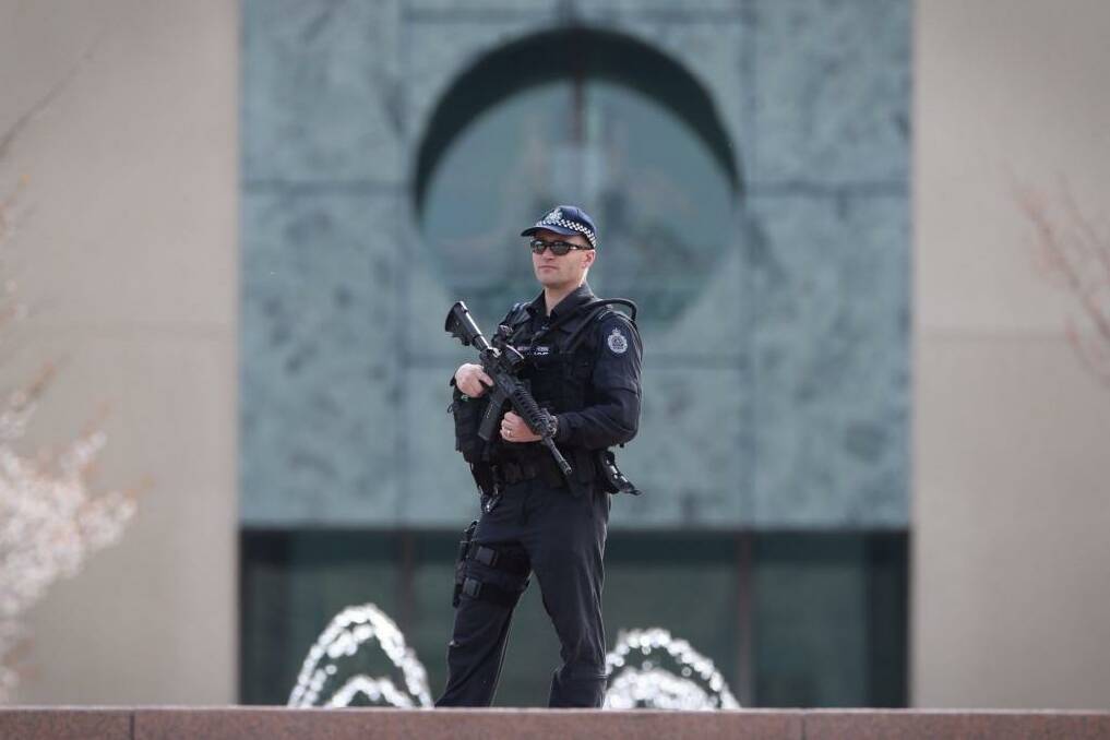 An AFP officer guards the perimeter of Parliament House as the government confirms a man shot dead in Melbourne was a ''known terror suspect''. Photo: Andrew Meares