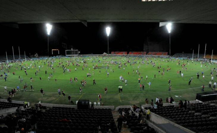 Sport. AFL NAB Cup match at Manuka Oval under lights between the GWS Giants and Essendon Bombers. Patrons on the field after the game. March 8th 2013 Photograph by Graham Tidy The Canberra Times.
