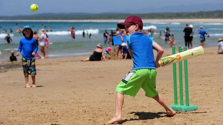 New Year's Day at South Broulee beach. A packed beach, beautiful weather and a wave to catch. Beach cricket was popular too, as 7 year old Joshua Evans, visiting from Sydney, scores a few runs.  Photo: Graham Tidy