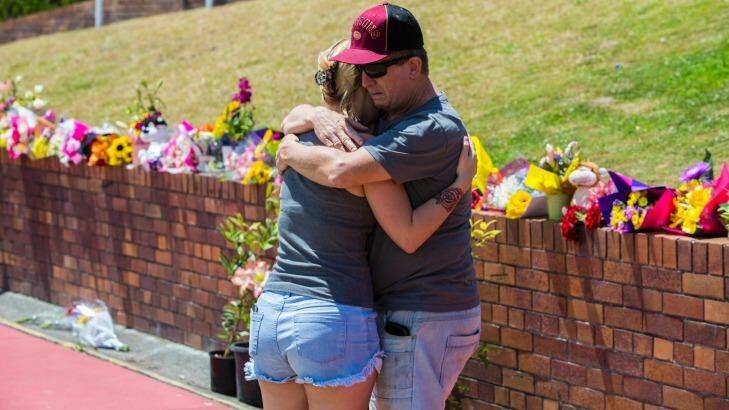 Locals grieve and leave flowers outside Dreamworld. Photo: Glenn Hunt
