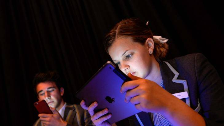 Teenagers spending too much time on electronic devices is raising concerns about inactivity and obesity. Sienna Withington and Daniel Marks using their devices. Photo: Justin McManus