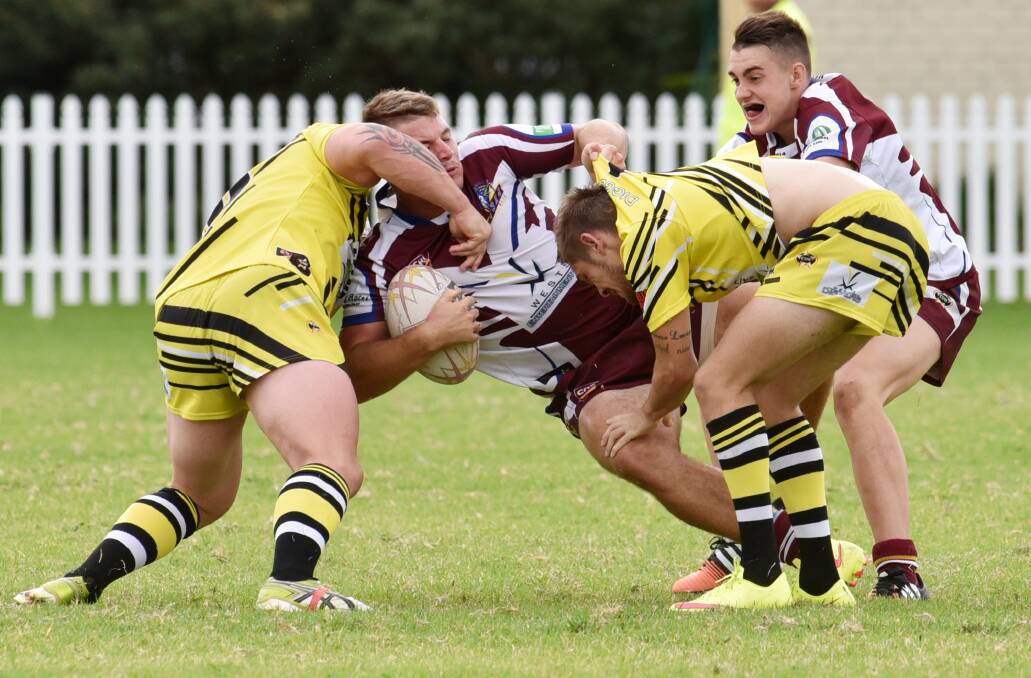 Oxley Diggers skipper Jamie Trindall (left) and Scott Berry take down Wests Lions back-rower Jake McLoughlin with Will Chesterfield in support. Both sides will be looking for away wins this weekend after the opening of Scully Park was pushed back. Photo: Geoff O’Neill 180415GOE07