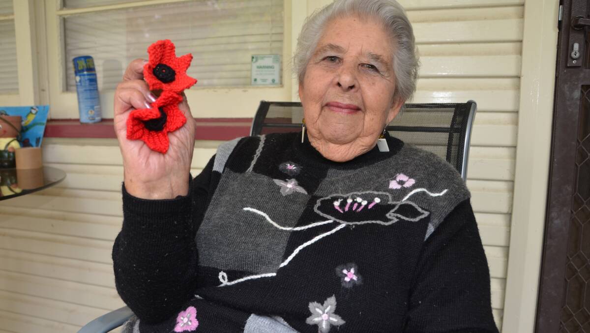 Dawn Smith with two of the poppies she crocheted.