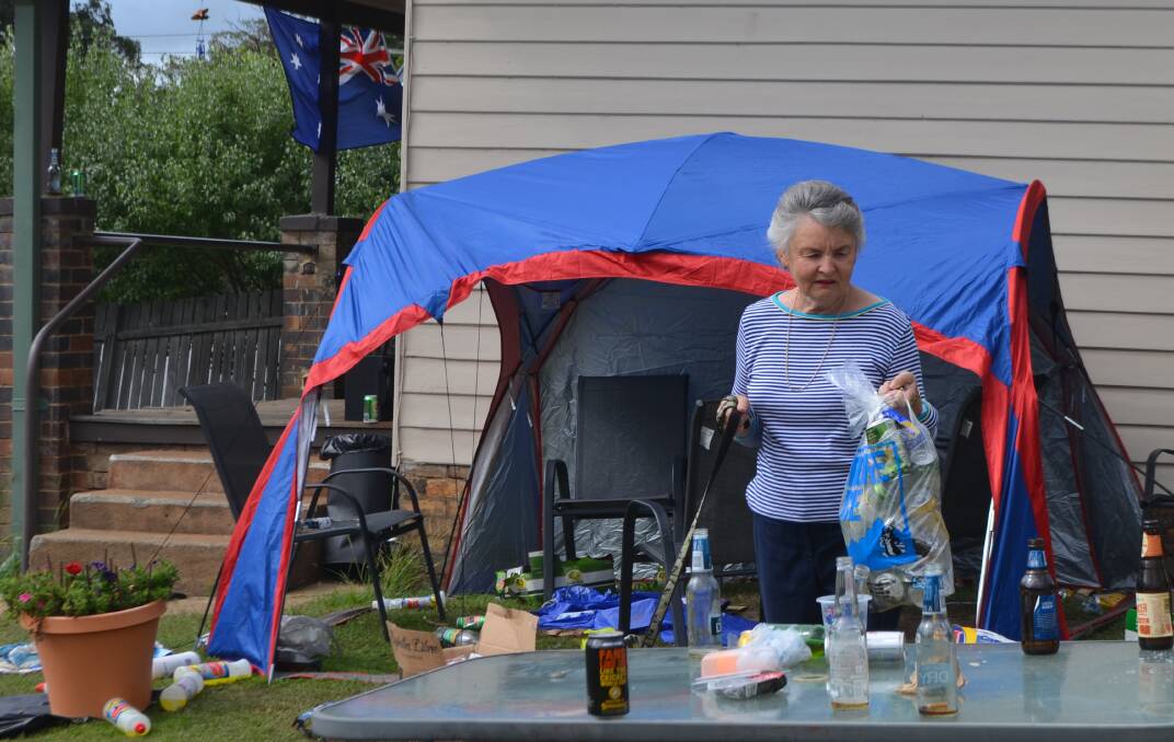 HELPING HAND: Newling Gardens resident Maree Bristow takes away some of the aluminium cans left over from the party. 