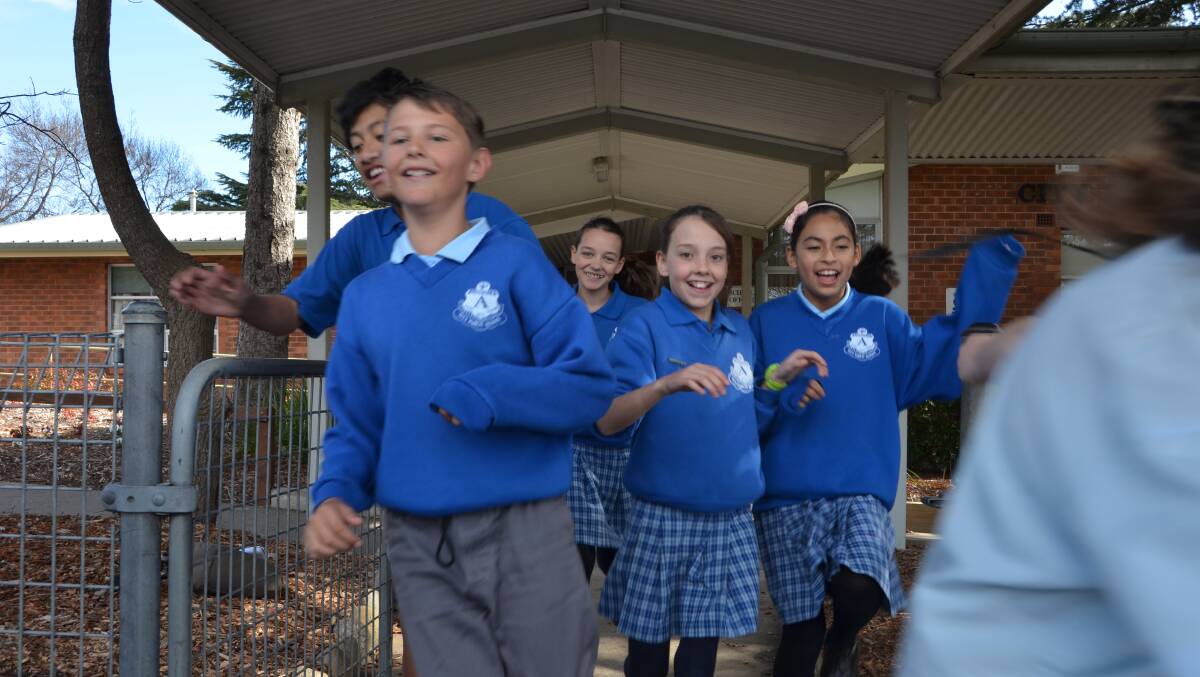 ECSTATIC: Students of Armidale Public School making a break for holiday freedom.