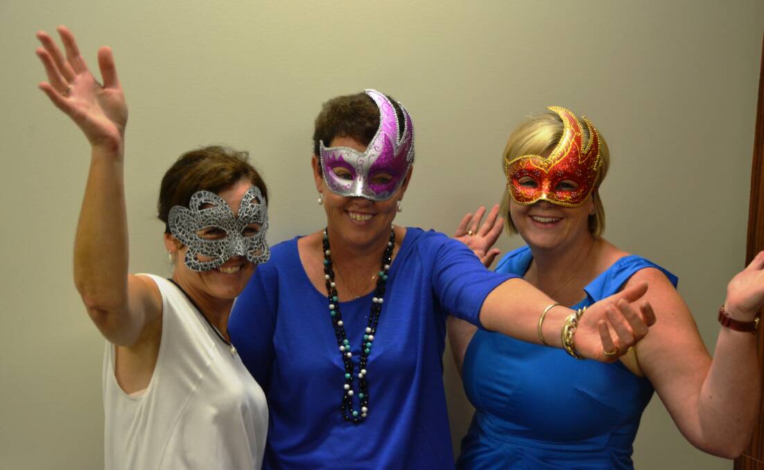 GLITTER GIRLS: Lee Boundy, Justine Biddle and Kay Endres may not be completely recognisable because of their masks, but they’re ready to have a ball.