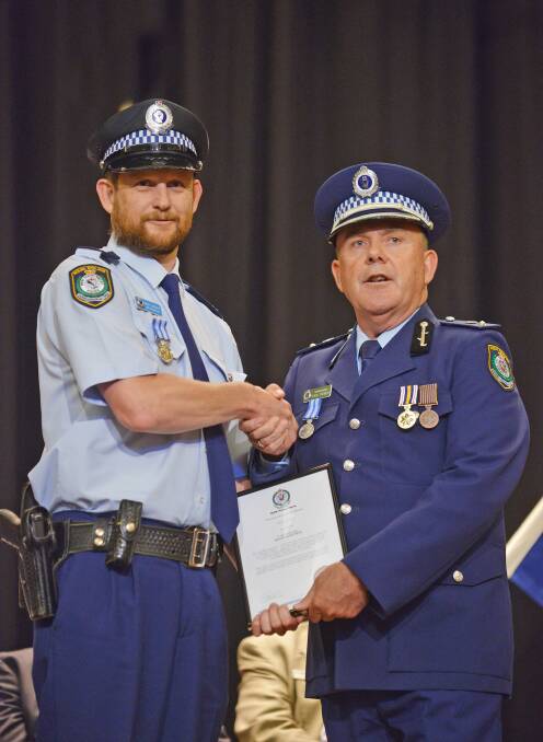 HEROES RECOGNISED: Armidale Senior Constable David Gayner is awarded a New England citation by New England Superintendent Fred Trench. Photo, BARRY SMITH.