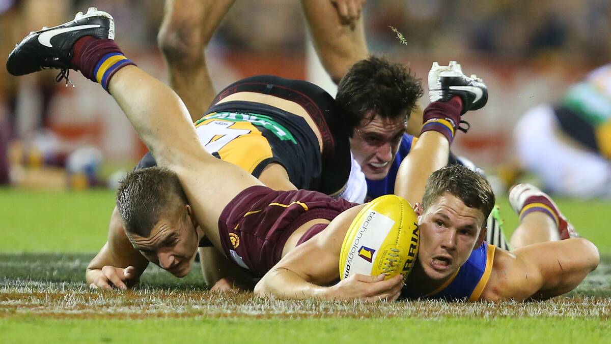 Jack Redden of the Lions is tackled by Dustin Martin of the Tigers during the round five AFL match between the Brisbane Lions and the Richmond Tigers at The Gabba on April 17, 2014 in Brisbane, Australia. Photo: Chris Hyde/Getty Images.