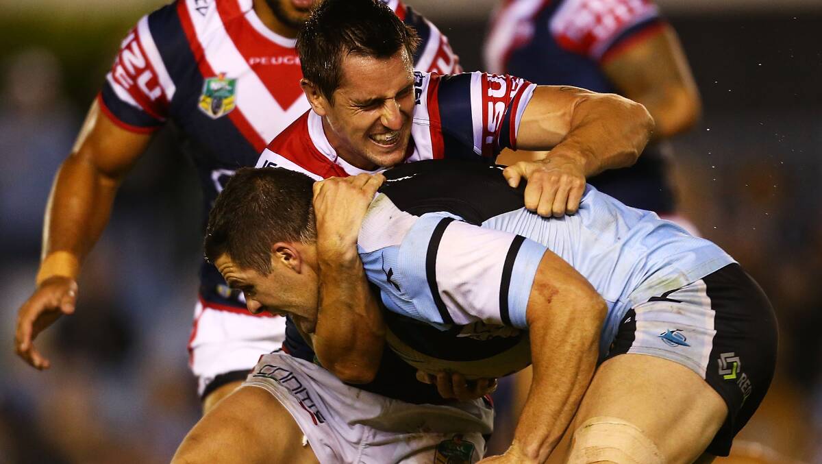 Mitchell Pearce of the Roosters tackles Michael Gordon of the Sharks during the round seven NRL match between the Cronulla-Sutherland Sharks and the Sydney Roosters at Remondis Stadium on April 19, 2014 in Sydney, Australia. Photo: Mark Nolan/Getty Images.