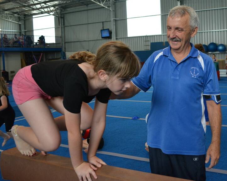 A HELPING HAND: Wally O’Hara coaches a young students at the Armidale Gymnastics Centre last month.