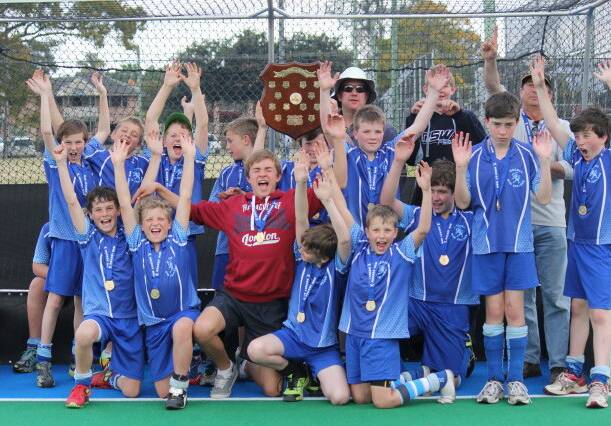 EXCITED: The New England under 13s boys hockey side celebrate after winning the C division state championship final in Grafton last weekend.
