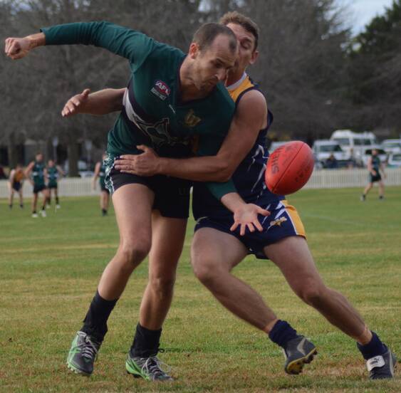 LINCHPIN: New England Nomads’ back Tom Granleese looks to handball as Narrabri’s Todd Dunn attempst to wrap him up.