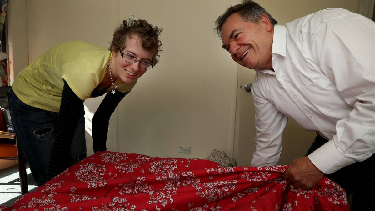 TUCKED IN: Pathfinders chief executive Alan Brennan and Armidale Youth Refuge resident Claire Sommerlad makes a bed with some of the manchester bought with the donation. Photo MATT BEDFORD