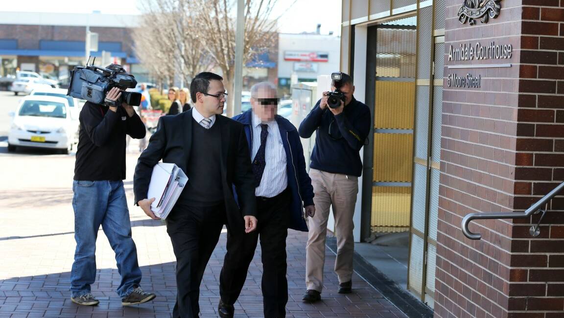 APPEARANCE: Defence solicitor Glen Kee escorts his client to Armidale Courthouse yesterday. The former priest will be pleaded guilty to 45 child sex offence charges. Photo: MATT BEDFORD
