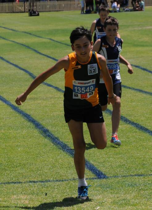 Armidale's Andre Cooper reaches the finish line in an under 12's 100m sprint.