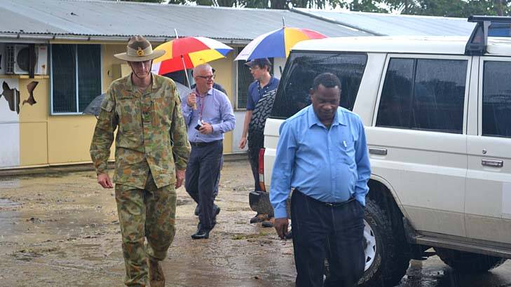 General Campbell, left, and Manus Island Police Chief  Alex N'Drasah, right, with immigration officials as they walk through the area where asylum seekers have been housed with criminals on Manus Island. Photo: Rory Callinan