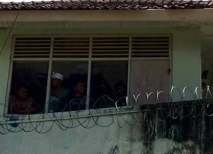 Prisoners are still in control of Kerobokan prison with some pictured here in a guard tower.