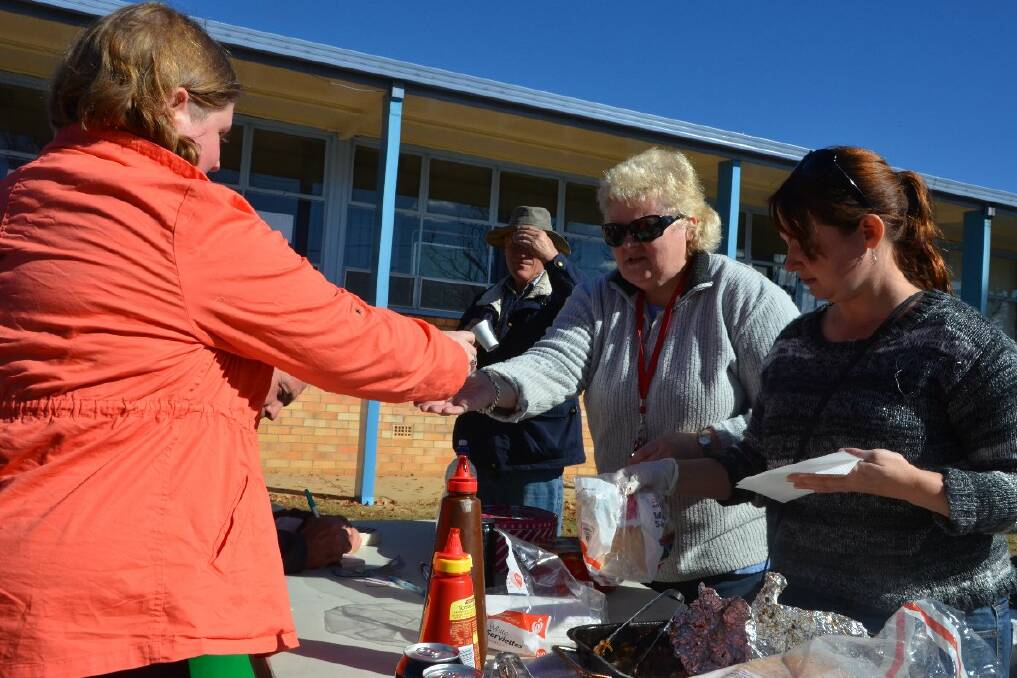 Susie Caton and Julie Crompton help out at Drummond Memorial School P&C's sausage sizzle.