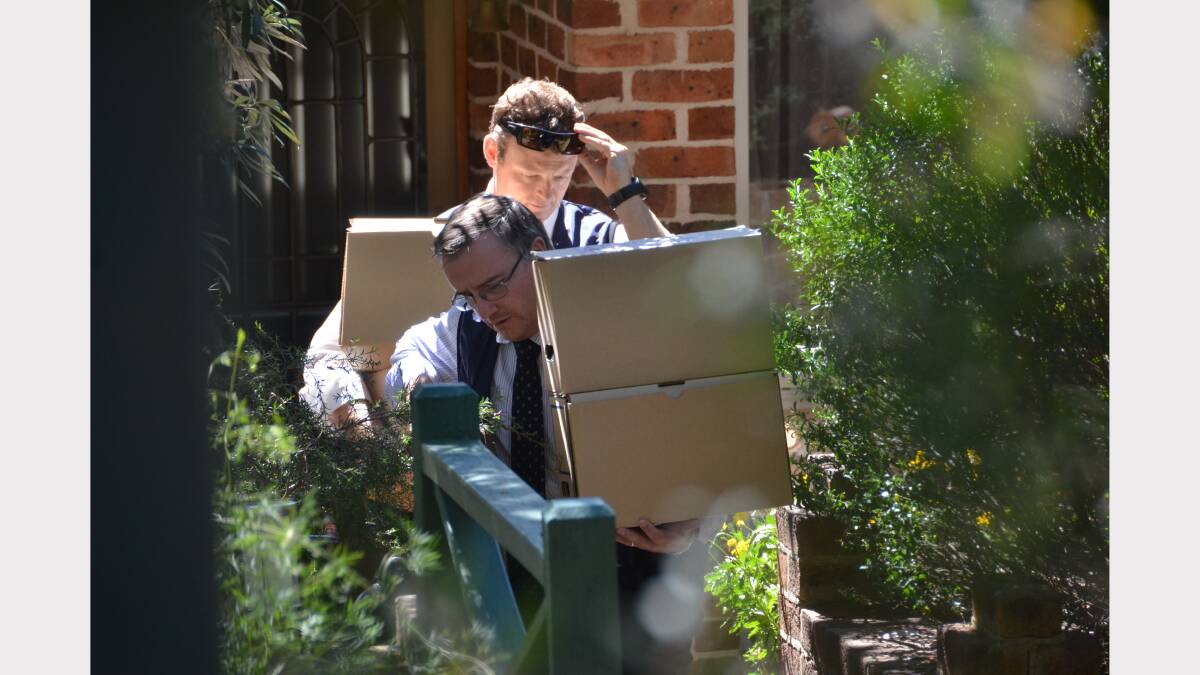 HAUL OF DOCUMENTS: Two ICAC officers leave Richard Torbay's house with four boxes of files at around 2.30pm.