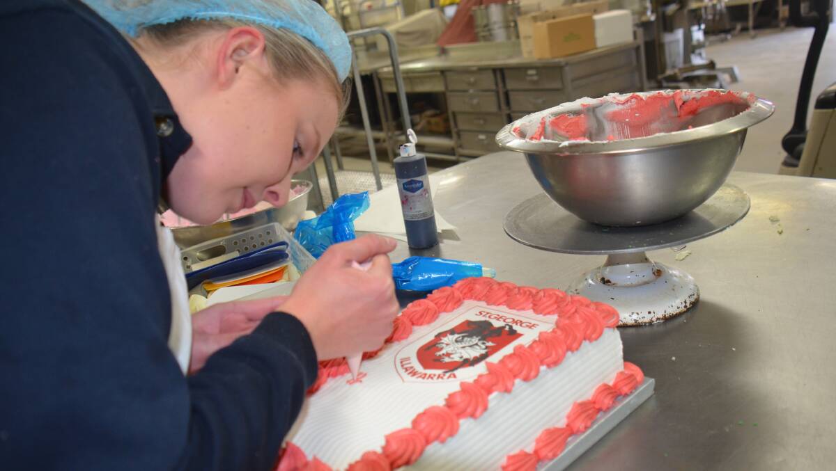 Kyah Valler, 22, puts the icing on a bespoke St. George Illawara Dragons cake. Ms Valler began working for Ann and Roger Bourke in their Moxon's Bakery in Armidale as a 16-year-old apprentice. Picture by Rachel Gray.