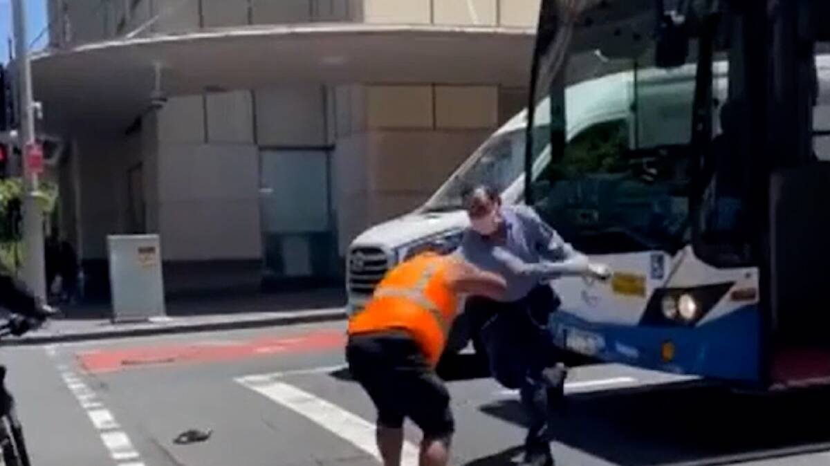 A still image from the video shows the bus and van drivers fighting