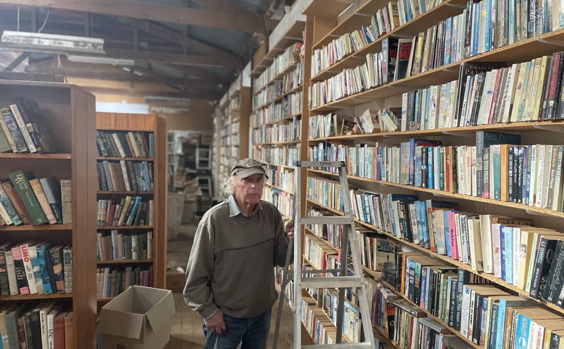 Chris Page with his mammoth collection of 20,000 books available for sale at the Walcha Antique shop which is listed on the real estate market. Photo Heath Forsyth 