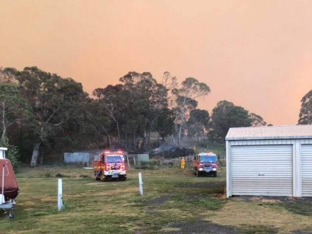 Battling the blaze: Fire crews work to protect homes in Ebor on Friday afternoon. Photo: NSW RFS