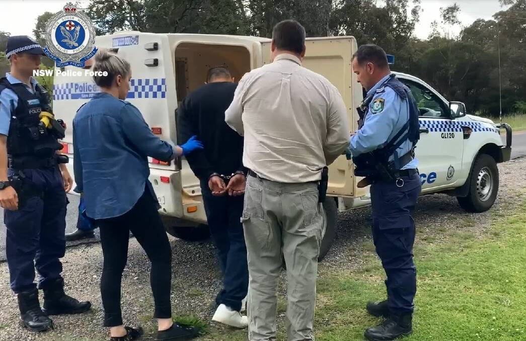 Under arrest: Detectives take Christopher James Levy into custody in Glen Innes on Wednesday. Photo: NSW Police