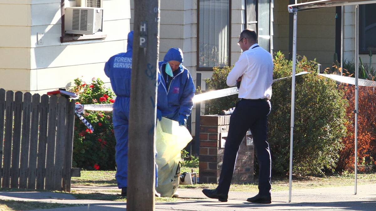Crime scene: Forensic police and a detective in Robert Street as officers canvassed the neighbourhood on March 29. Photo: Breanna Chillingworth