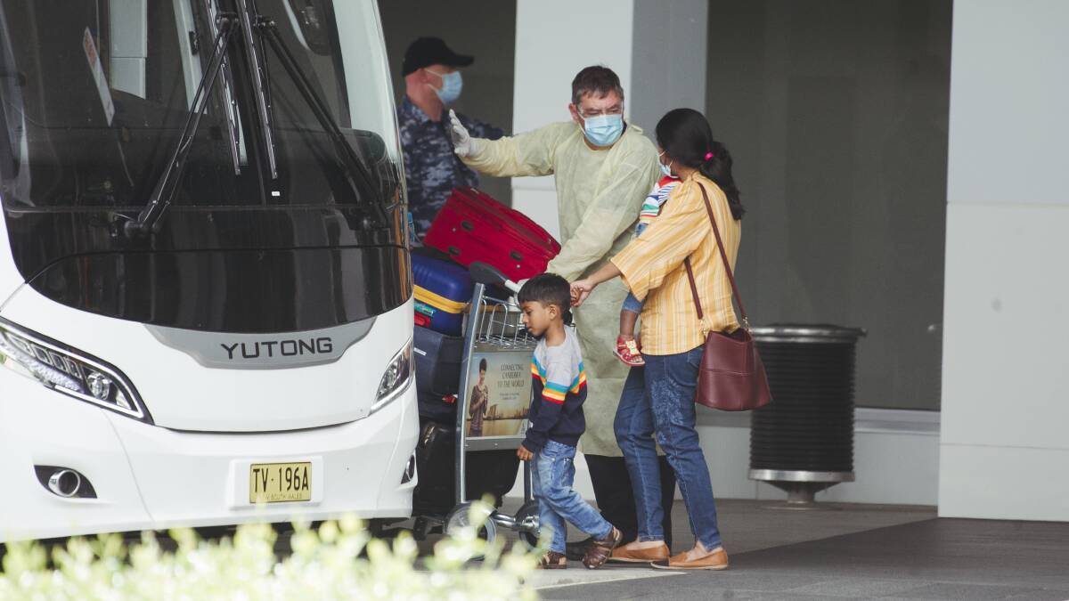Passengers from the Chennai to Canberra flight board buses to take them to their quarantine hotel. Picture: Dion Georgopoulos