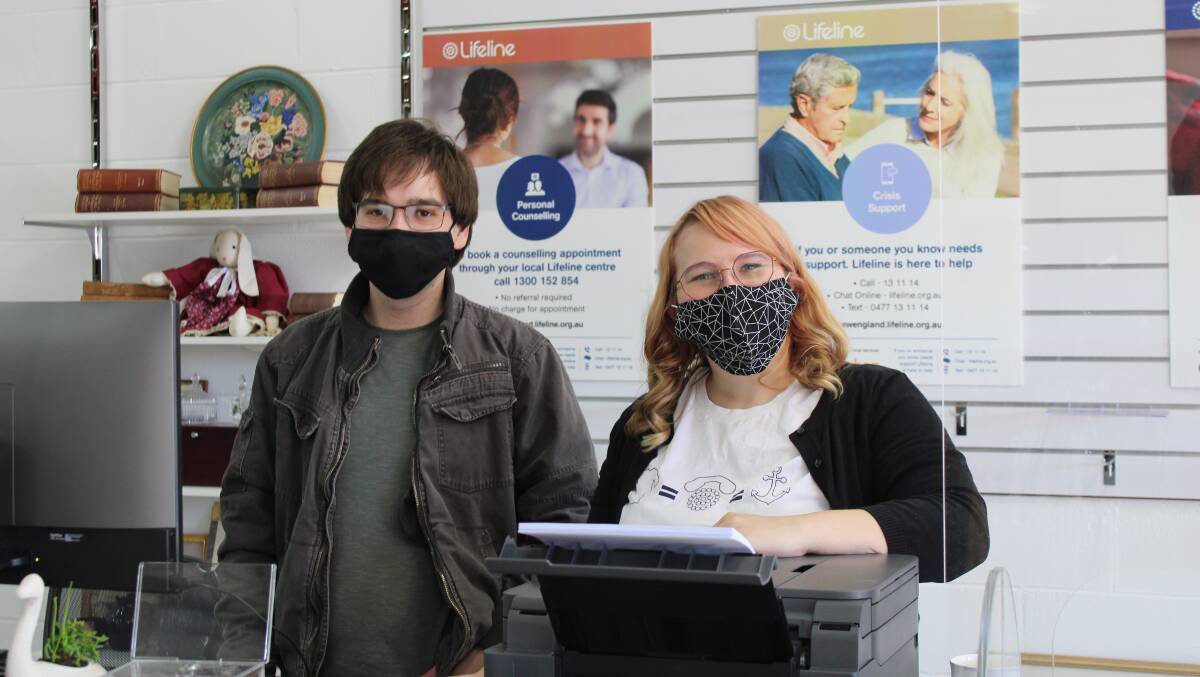  LENDING A HELPING HAND: Aaron Harris and Jess Woods setting up the new Lifeline shop in Armidale.Photo supplied.