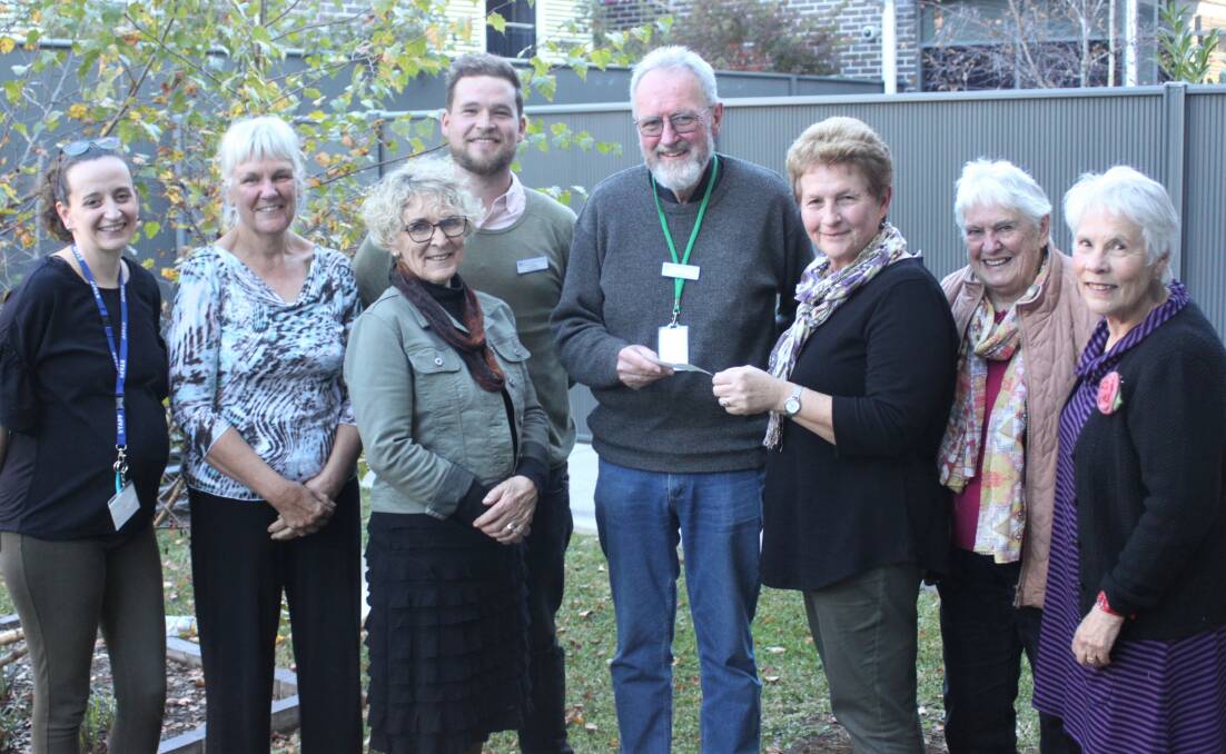 Members of the Quilters and Patchworkers of New England present Paul Robinson with a cheque for Freeman House last month