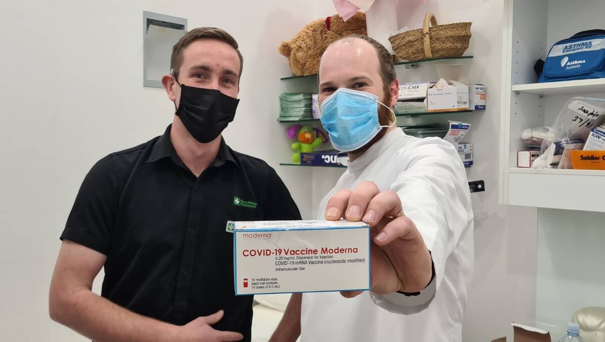 LEADING THE WAY: Aidan Rowston and Daniel Flavel pictured with the Moderna COVID-19 vaccine at Terry White Chemmart Armidale. Photo supplied.