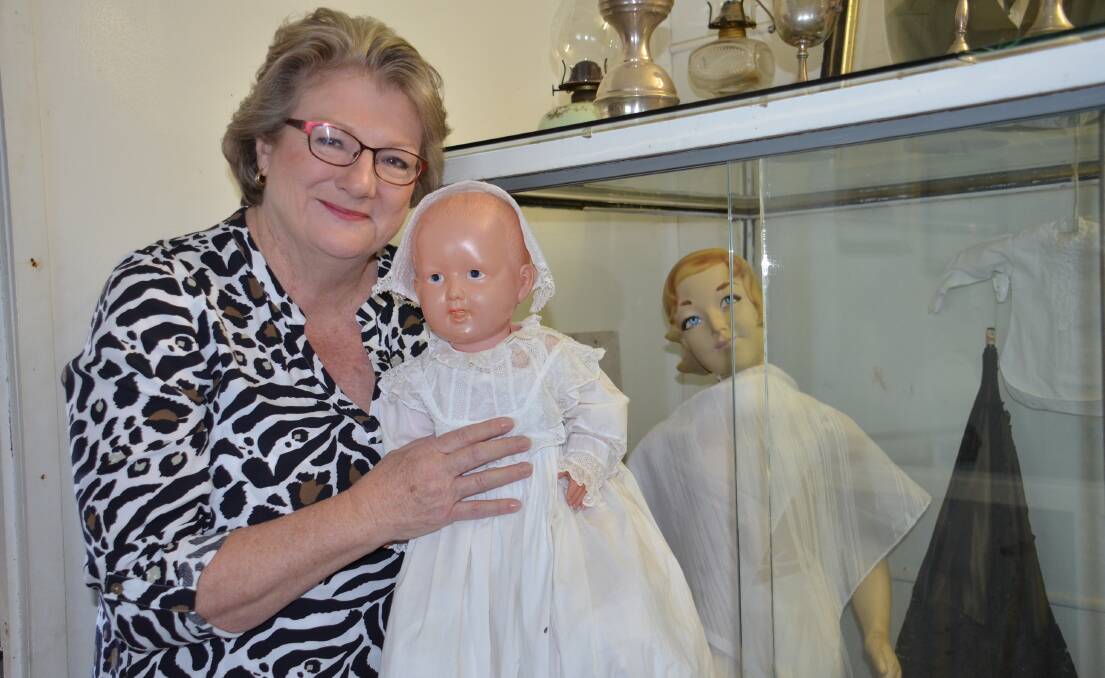 Walcha Historical Society secretary Jane Morrison  with one of the christening gowns