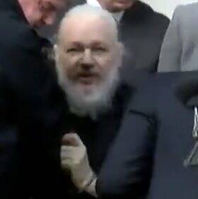 Julian Assange (inset) as he was taken from the embassy.