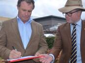 Armidale mayor Sam Coupland signs the petition on Tuesday alongside Northern Tablelands MP Adam Marshall. Picture: Laurie Bullock