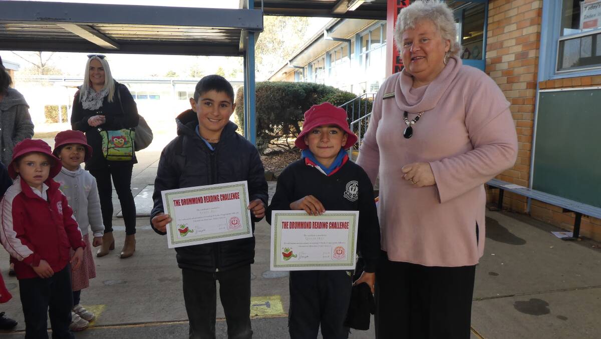 A NEW LIFE: Yazidi children Aymen Hilo and Qaidar Jaralla receive certificates from their principal for completing 20 books in the Reading Challenge.