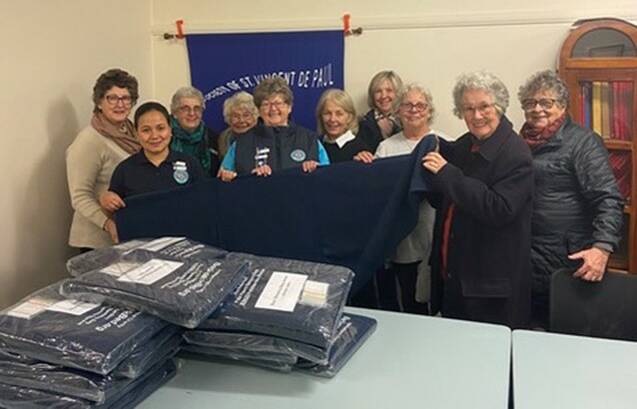 CWA Armidale Branch members (from left) Sharron Chappell, Eva Raue, Helen Browning, Ruth Blanch, Llani Pevitt (President), Pam Hulme, Donna Harris and Eleanor Austin handing over a delivery of sleeping bags to SVDP St Louise members, Veronica Ryan and Robyn Driscoll.